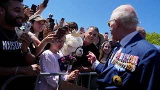 König Charles III. spricht mit einem Alpaka, das ihn gerade angeniest hat, am Australischen Kriegsdenkmal in Canberra