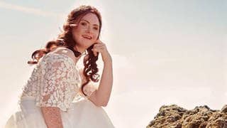 Das Model Tamara Röske sitzt in einem Brautkleid auf einem Stein