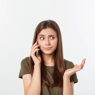 Frau versucht am Telefon, ihren Namen zu buchstabieren