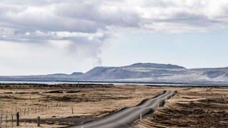 Rauchwolken über dem Vulkan Fagradalsfjall mit der kleinen Straße Guðnabær nahe der Ortschaft Þorlákshöfn im Süden Islands