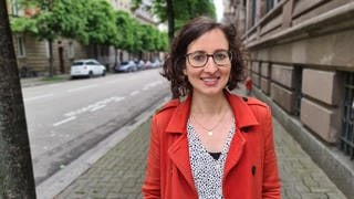 Katerina ist sogenannte Grenzgängerin, trägt einen roten Mantel und lacht in die Kamera