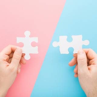 Hände halten jeweils zwei ineinander passende Puzzle-Teile. Symbolbild für Quiz zur Rechtschreibung von Wörtern: Wann schreibt man zusammen, wann getrennt?