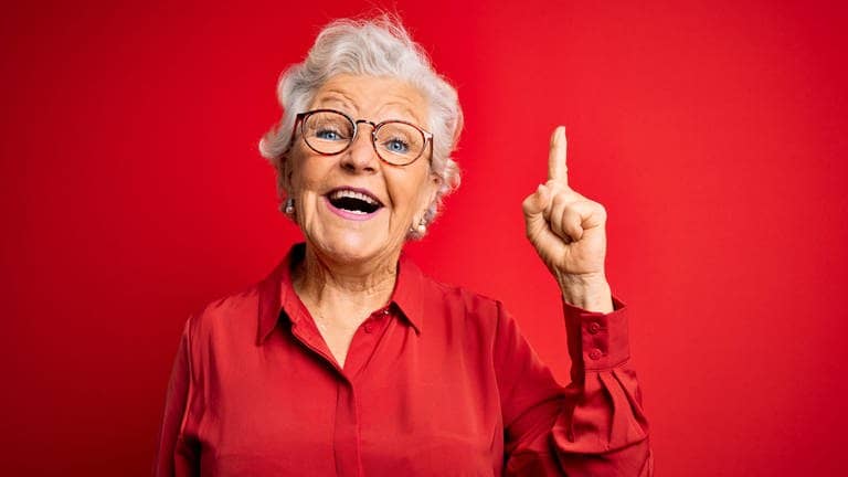 Coole Oma hebt lächelnd den Finger. Symbolbild für den Generator mit klugen Weisheiten von Großeltern.