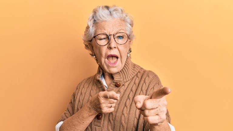 Coole Oma zwinkert und zeigt mit dem Fingern in Richtung Betrachter. Symbolbild für den Generator mit klugen Weisheiten von Großeltern.