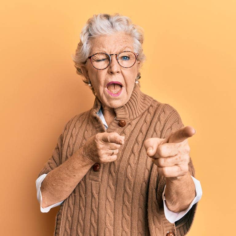 Coole Oma zwinkert und zeigt mit dem Fingern in Richtung Betrachter. Symbolbild für den Generator mit klugen Weisheiten von Großeltern.