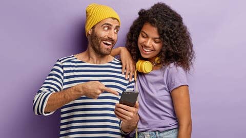 Ein junger Mann und eine junge Frau schauen zusammen begeistert aufs Smartphone. Symbolbild für den Whatsapp-Kanal von SWR3.
