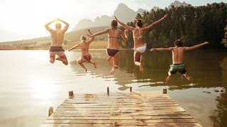 Junge Leute springen in einen See