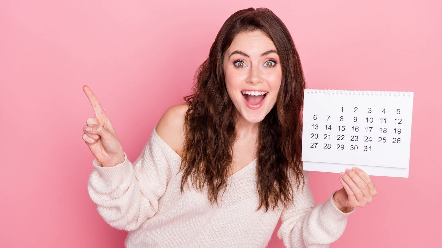 Junge Frau mit Kalender in der Hand. Symbolbild für Brückentage und Feiertage in 2025 – clever den Urlaub planen!