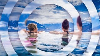 Zwei junge Frauen in einem Pool mit Ausblick auf ein Alpenpanorama Symbolbild für Gewinnspiel: Gutschein für Urlaub in Südtirol gewinnen.