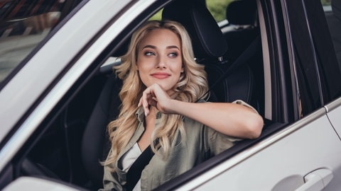 Junge Frau sitzt nachdenkend in einem Auto. Symbolbild für unbekannte Verkehrsschilder in Deutschland und ihre Bedeutung.