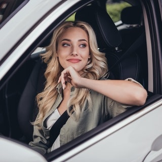 Junge Frau sitzt nachdenkend in einem Auto. Symbolbild für unbekannte Verkehrsschilder in Deutschland und ihre Bedeutung.