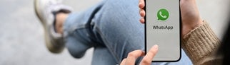 Junge Frau mit Smartphone in der Hand. Beim Messenger Whatsapp können Sprachnachrichten bald in Text umgewandelt und transkribiert werden.