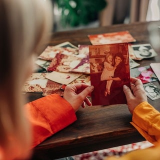 Zwei Personen schauen sich ein Foto an – das kann bei Trauer helfen.