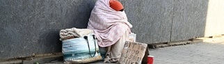 Obdachlose Person beim Betteln um Geldspenden und Sachspenden