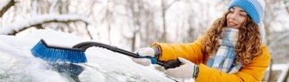 Junge Frau beim Eiskratzen: Die Autoscheibe ist im Winter auch von innen gefroren und vereist. 