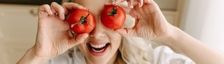 Frau hält sich Tomaten über die Augen. Symbolbild für das SWR3 Quiz zu Redewendungen: „Hast du Tomaten auf den Augen?“