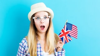 Junge Frau schaut fragend, in der Hand hält sie eine England-Flagge. Symbolbild für 50 deutsche Redewendungen – sinnfrei, aber lustig übersetzt.