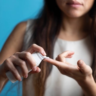 Eine Frau trägt Handcreme auf – Stiftung Warentest hat mehrere getestet.