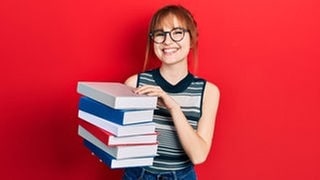 Frau mit Brille hält einen Stabel Bücher auf dem Arm, da sie die Buchtipps von SWR3 mitbekommen hat