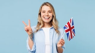 Junge Frau mit England-Flagge in der Hand. Symbolbild für 50 deutsche Redewendungen, wörtlich übersetzt auf Englisch.