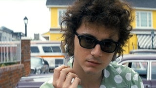 Bob Dylan mit Sonnenbrille und Zigarette. Timothée Chalamet verkörpert den jungen Bob Dylan, der in den 60er-Jahren von Minnesota nach New York kommt. 