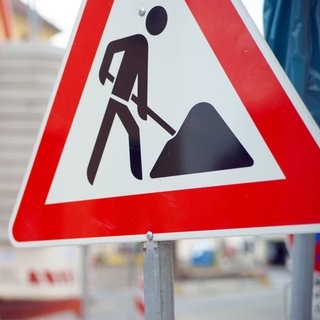 Baustellen-Schild an einer Straße. Symbolbild für lustige Sprüche auf der Baustelle.