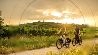 Ein Mann und eine Frau fahren auf den E-Bikes aus dem SWR3 Gewinnspiel der SWR3 E-Bike-Challenge durch SWR3Land und genießen den Frühling.