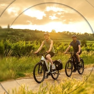 Ein Mann und eine Frau fahren auf den E-Bikes aus dem SWR3 Gewinnspiel der SWR3 E-Bike-Challenge durch SWR3Land und genießen den Frühling.