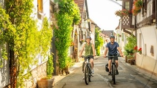 Ein Mann und eine Frau fahren auf den E-Bikes aus dem SWR3 Gewinnspiel der SWR3 E-Bike-Challenge durch SWR3Land und genießen den Frühling.