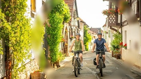 Ein Mann und eine Frau fahren auf den E-Bikes aus dem SWR3 Gewinnspiel der SWR3 E-Bike-Challenge durch SWR3Land und genießen den Frühling.