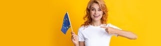 Junge Frau zeigt lachend auf eine Europa-Flagge. Symbolbild für ein Quiz zu Sprachen in Europa