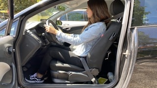 Frau sitzt im Auto in aufrechter Position