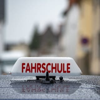 Fahrschule Schild auf Auto. Es handelt sich für ein Symbolbild für die neuen Fragen der Führerscheinprüfung ab April 2024