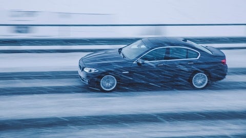 Bei Glatteis fahren: Schwarzes Auto fährt über Glatteis