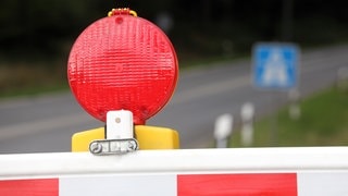 Eine Warnbake steht vor einem Autobahnschild (Symbolbild)