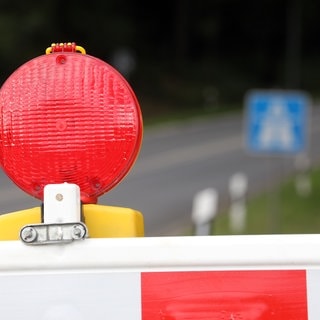 Eine Warnbake steht vor einem Autobahnschild (Symbolbild)