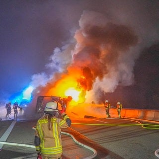 Feuerwehrleute löschen einen brennenden Lkw auf der A6 bei Bad Rappenau (Kreis Heilbronn)