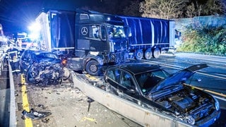 Ein Lkw, der Unfälle auf der A1 und A46 in NRW verursacht hat, steht quer auf der Fahrbahn, daneben zwei stark beschädigte Autos