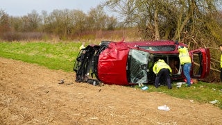 Ein zerstörtes Auto liegt nach einem Unfall auf der A6 auf einem Feld. Zwei Menschen sind gestorben.