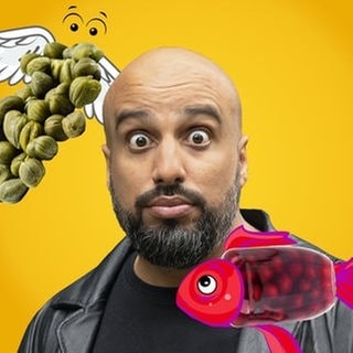 Comedian Abdel Karim zwischen zwei sehr komischen Tieren. Einmal fliegende Kapern und einmal ein Fisch mit Schattenmorellen-Kleid. Hintergrund ist ein Sketch von Abdelkarim bei dem es um Lebensmittelgeht, deren Namen so klingen, als dass es auch ein Tier sein könnte.