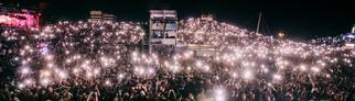 Publikum bei Nacht hält Lampen hoch