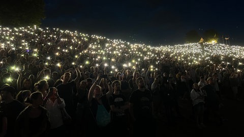 Der Hügel bei Das Fest in Karlsruhe leuchtet in der Nacht so wunderschön dank der vielen Menschen mit ihren Handylichtern