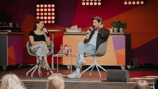 Beim SWR Sommerfestival nehmen Sally Özcan und Max Giesinger eine Folge des Podcasts 1 plus 1 – Freundschaft auf Zeit auf.