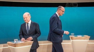 Bundeskanzler Olaf Scholz (SPD, l), steht neben Friedrich Merz, Unions Kanzlerkandidat und CDU Bundesvorsitzender, vor dem TV-Duell von ARD und ZDF