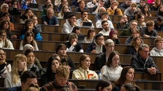 Studierende nehmen an der Einführungsveranstaltung im Audimax der Ludwig-Maximilians-Universität (LMU) teil.