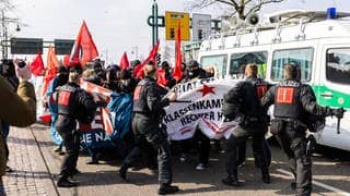 Polizisten schlagen mit Schlagstöcken auf Demonstranten ein, um den Demonstrationszug gegen den Landesparteitag der AfD Baden-Württemberg zu stoppen