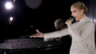 Céline Dion mit Mikrofon in der Hand sorgt bei der Eröffnungsfeier für große Emotionen.