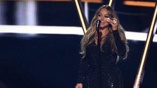 Mariah Carey trauert um Tod von Mutter & Schwester | Im Bild steht Mariah Carey im schwarzen Kanzkörperanzug vor dem Mikro-Ständer und hält ein Taschentuch in der Hand.