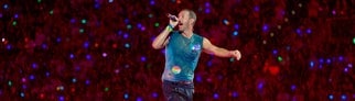 Chris Martin, Sänger der britischen Band Coldplay steht bei einem Konzert im Rahmen der „Music of the Spheres Tour 2024“ bei strömendem Regen in der Merkur auf der Bühne.