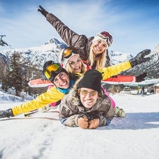 Eine Gruppe von Freunden liegt aufeinander und feiert beim Après-Ski den Hit „Wackelkontakt“ von Oimara 